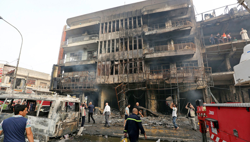 epa05404927 Fire rescue workers at the site of suicide car bomb attack in the Karada district of central Baghdad, Iraq, 03 July 2016. At least 23 people were killed and 70 others were wounded in a suicide car bomb attack targeted Karada district of Baghdad and other attack by a roadside bomb in Shaab market , Iraqi police said.  EPA/ALI ABBAS