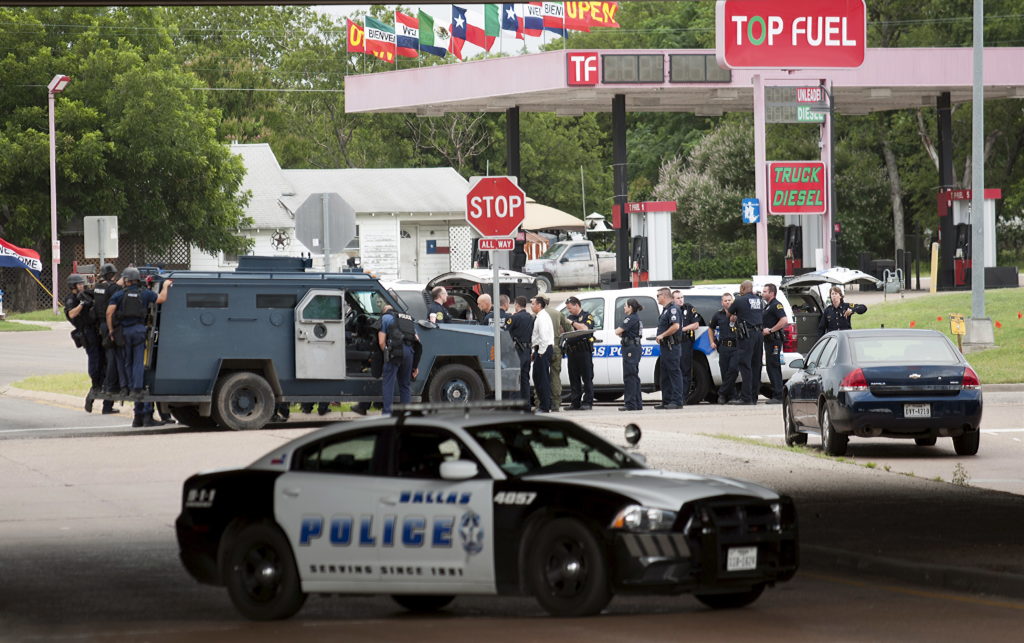 Police vehicles are seen in the city of Hutchins, south of Dallas, Texas June 13, 2015. Shots were fired from an armored van in an attack on Dallas Police headquarters early on Saturday, police said, and an explosive device was later found outside the building. REUTERS/Rex Curry - RTX1GCN0