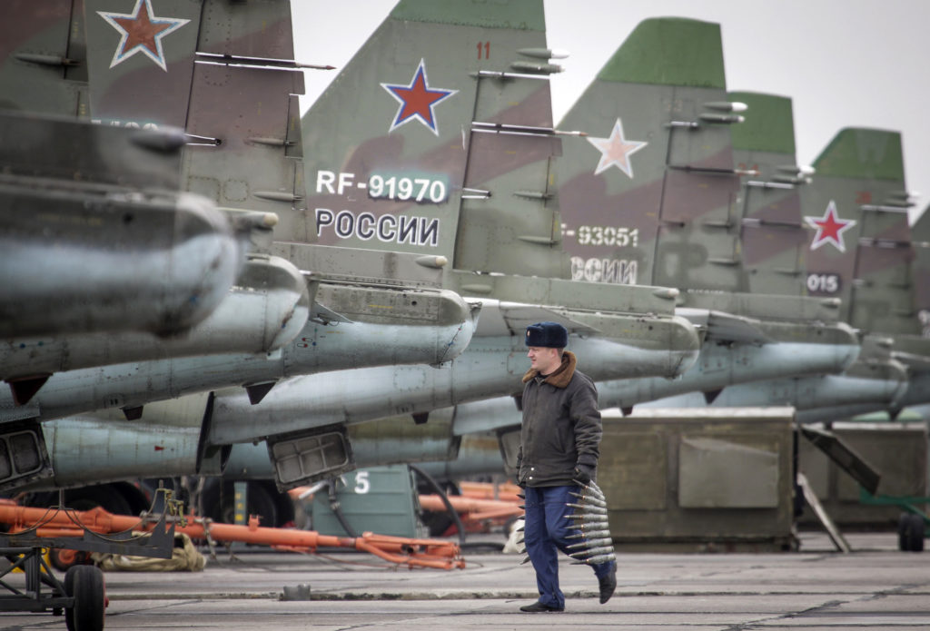 A serviceman carries ammunition next to Sukhoi Su-25 jet fighters during a drill at the Russian southern Stavropol region, March 12, 2015. Russia has started military exercises in the country's south, as well as in Georgia's breakaway regions of South Ossetia and Abkhazia and in Crimea, annexed from Ukraine last year, news agency RIA reported on Thursday, citing Russia's Defence Ministry. REUTERS/Eduard Korniyenko (RUSSIA - Tags: POLITICS CIVIL UNREST MILITARY) - RTR4T43O