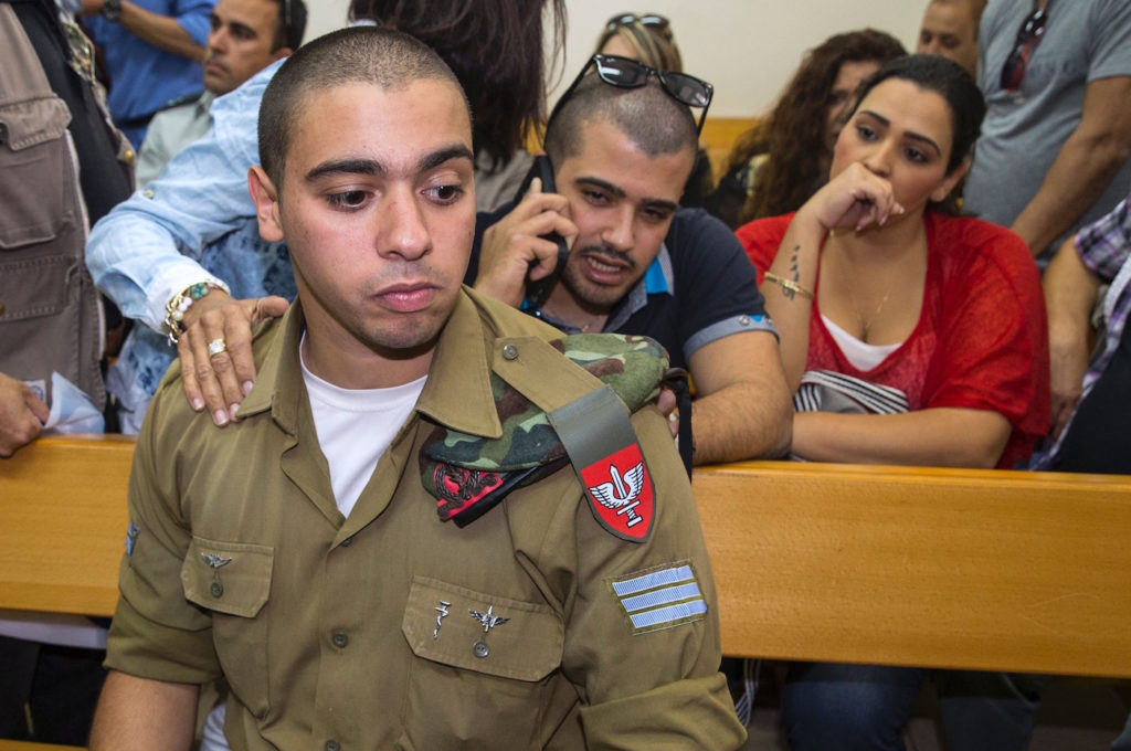 Israeli soldier Elor Azaria, who was caught on video shooting a wounded Palestinian assailant in the head as he lay on the ground, sits during a hearing at a military appeals court in Tel Aviv during which he was charged with manslaughter on April 18, 2016. Prosecutors presented the indictment to a military court over the March 24 killing, which occurred minutes after the Palestinian had stabbed another soldier and lay prone on the ground wounded by gunfire, according to Israeli authorities. He was also charged with conduct unbecoming of his rank and position in the army.  / AFP / JACK GUEZ        (Photo credit should read JACK GUEZ/AFP/Getty Images)