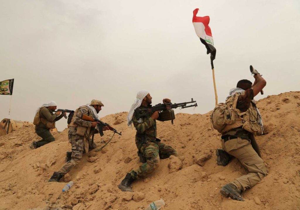 Fighters from Badr Brigades Shiite militia clash with Islamic State group militants at the front line on the outskirts of Fallujah, Anbar province, Iraq, Monday, June 1, 2015. Three Islamic State suicide bombers targeted a police base in the Tharthar area north of Ramadi, some 30 miles (48 kilometers) west of Fallujah, with explosives-laden Humvees on Monday, killing at least 41 police and Shiite militiamen, officials said. (AP Photo/Hadi Mizban)
