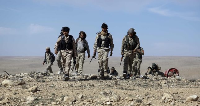 Fighters from the Syrian Democratic Forces (SDS) gather on the outskirts of the town of Chaddade in the northeastern Syrian province of Hasaka, on February 19, 2016. The Syrian Democratic Forces (SDS), an alliance dominated by the Kurdish People's Protection Units (YPG), seized on Friday the town of Chaddade, a bastion of the Islamic State group (IS) in the Hasaka province, in northeastern Syria, according to the Syrian Observatory for Human Rights. / AFP / Delil souleiman